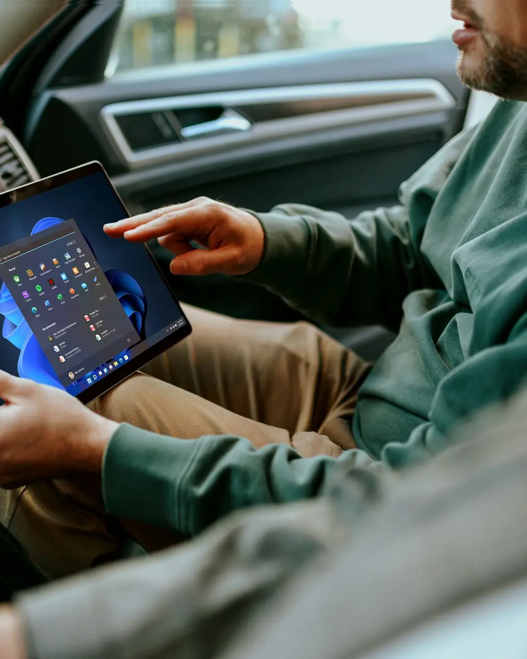 A driver in the cab of a van, checking a tablet before setting off